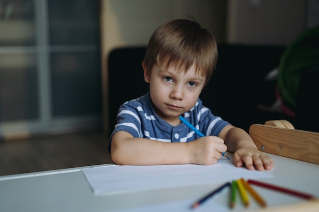 選択的な焦点で色鉛筆の画像で情熱的に描く愛らしい小さな幼児の男の子