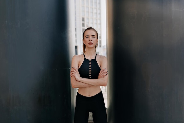 Adorable lovely woman in sportswear is posing during training\
outdoors stretching legs on the steps of stairs outdoor in the city\
breaking relax while exercise workout concept of health