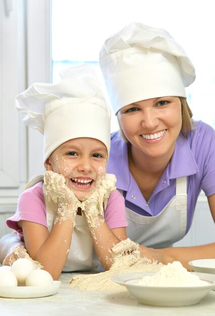 Adorable mother and daughter cooking together in the kitchen