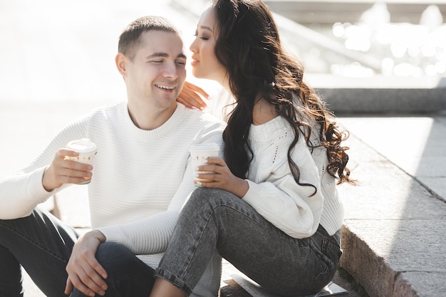 Adorable multiracial couple outdoors. Young people have a date. Woman and man happy together.