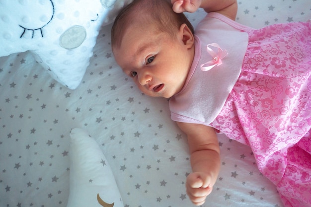 Adorable newborn baby girl in pink dress