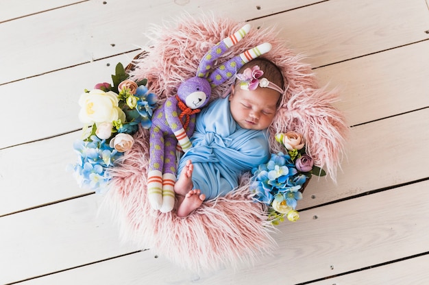 Photo adorable newborn with toy sleeping in basket