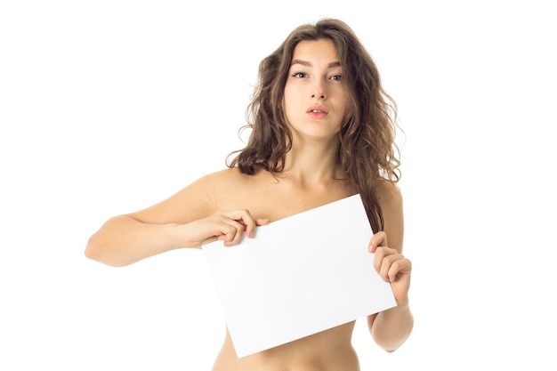 Adorable nude brunette woman with placard isolated on white wall