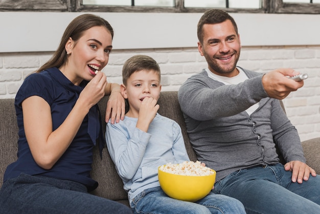 Очаровательные родители с сыном смотрят фильм