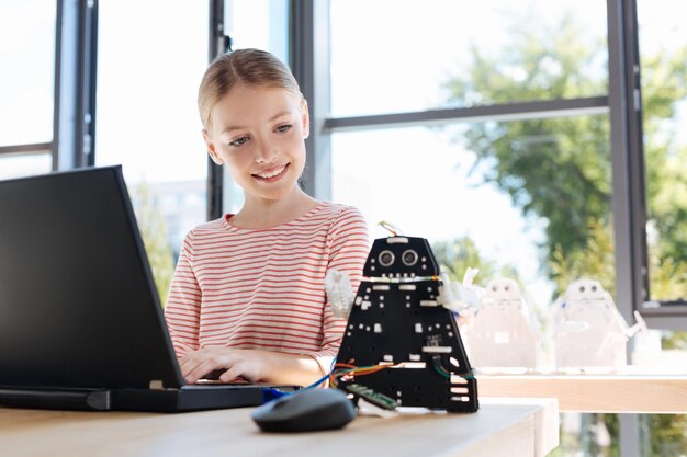 Adorable pre-teen kids inspecting robotic vehicle workshop