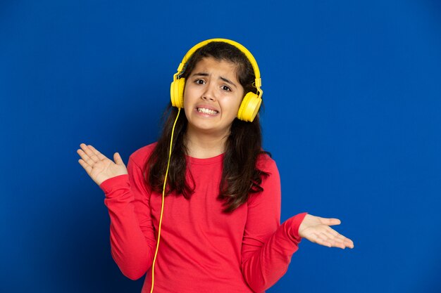 Adorable preteen girl with red jersey gesturing over blue wall