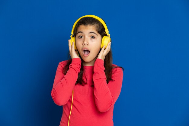 Adorable preteen girl with red jersey gesturing over blue wall