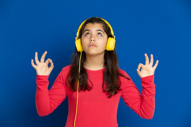 Adorable preteen girl with red jersey gesturing over blue wall