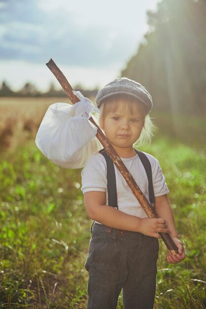 Фото Очаровательный грустный уличный ребенок в поле на закате