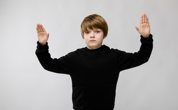  adorable serious little boy standing with hands up