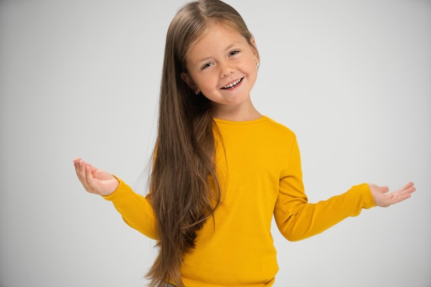 Adorable six years old girl isolated on white pretty brownhaired european child pose indoor smiling look at camera