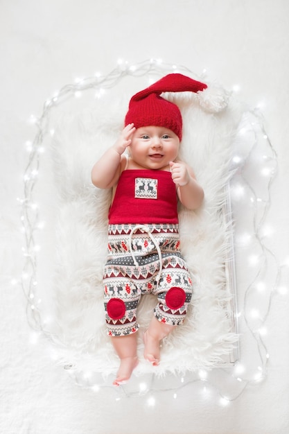 Adorable sleeping newborn baby wearing Santa Claus hat Christmas New Year