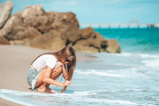 Adorabile ragazza adolescente si diverte in spiaggia tropicale durante le vacanze