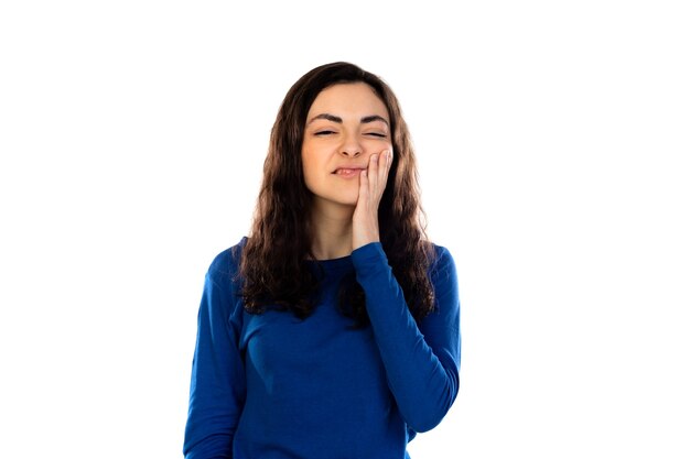 Adorable teenage girl with blue sweater isolated on a white wall