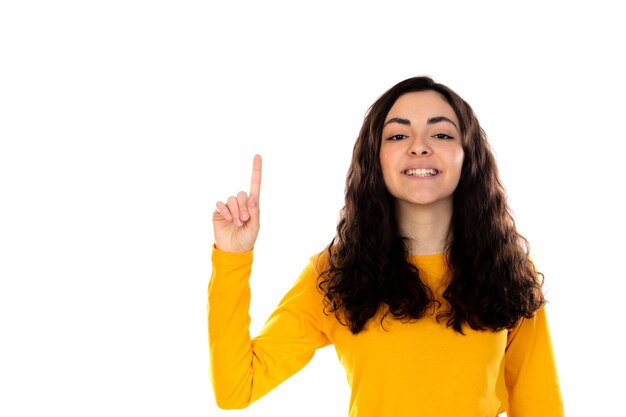 Adorable teenage girl with yellow sweater isolated on a white wall