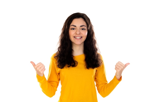 Adorable teenage girl with yellow sweater isolated on a white wall