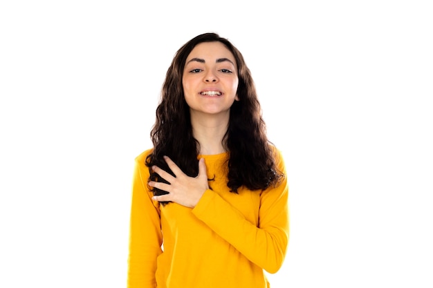 Adorabile ragazza adolescente con maglione giallo isolato su un muro bianco