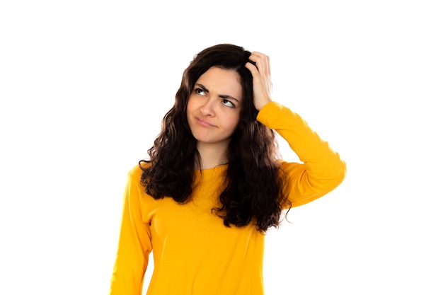 Adorable teenage girl with yellow sweater isolated on a white wall