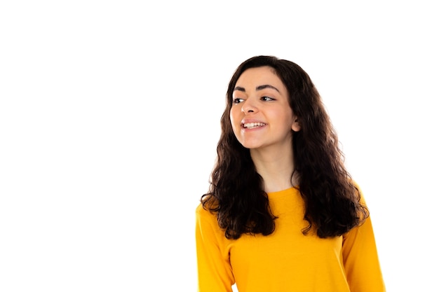Очаровательная девочка-подросток с желтым свитером, изолированным на белой стене