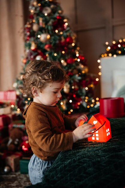 Adorable toddler boy playing with paper light up house