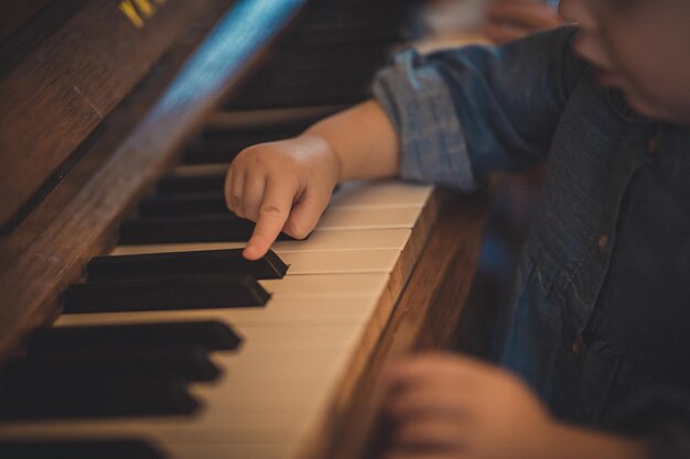 Adorable toddler child learning to play the piano