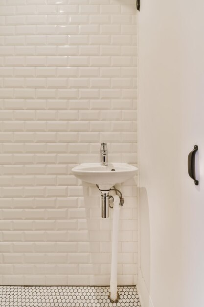 Photo adorable washbasin with white tiled walls