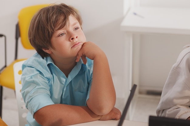 Adorable young boy looking away thoughtfully