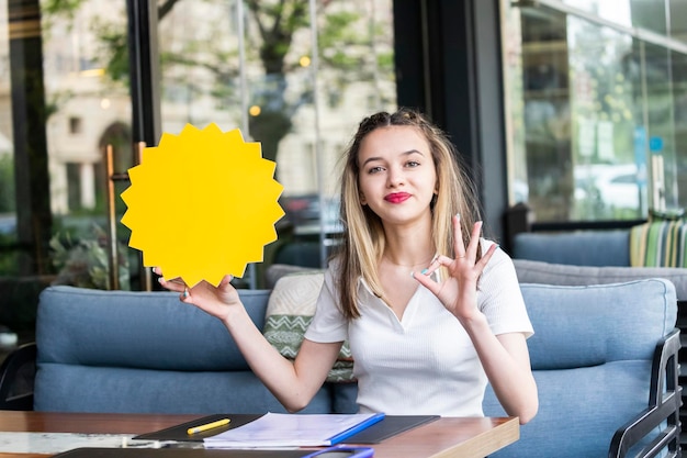 Adorable young girl holding idea board and gesture OK