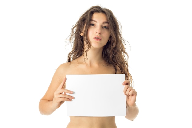 Adorable young sexy nude brunette woman with placard isolated on white wall