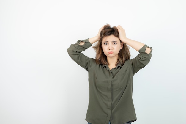 Adorable young woman in casual outfit standing and thinking. High quality photo