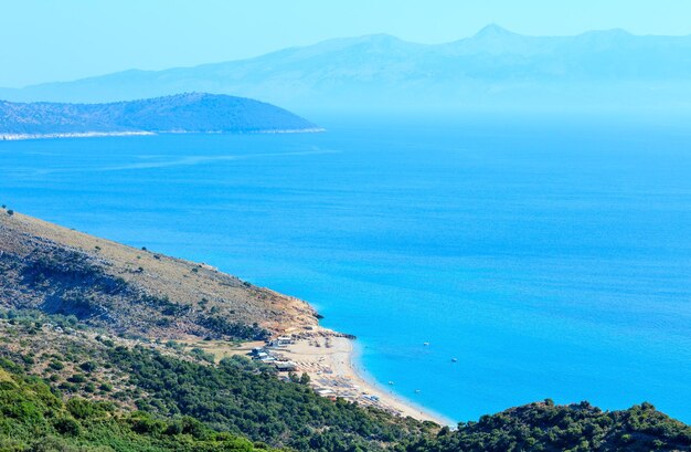 Adriatische Zee zomerkust met strand en het eiland Corfu in mist (Lukove komuna, Albanië). Uitzicht vanaf bergpas.