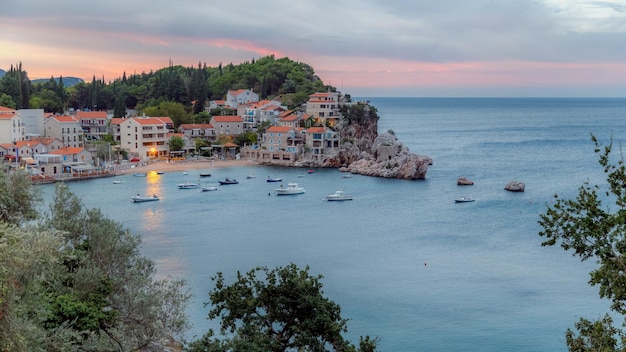 Adriatische Zeekust en Przno-dorp op de rotsen in Budva Riviera voor zonsopgang. Montenegro.