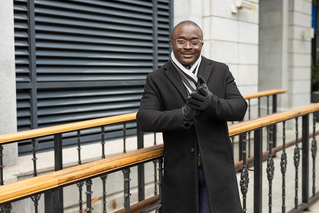 Uomo africano adulto con gli occhiali in cappotto nero