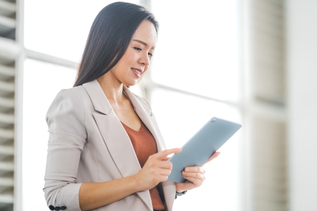 Adult Asian Businesswoman Using Digital Tablet Computer and Working Outdoors Office