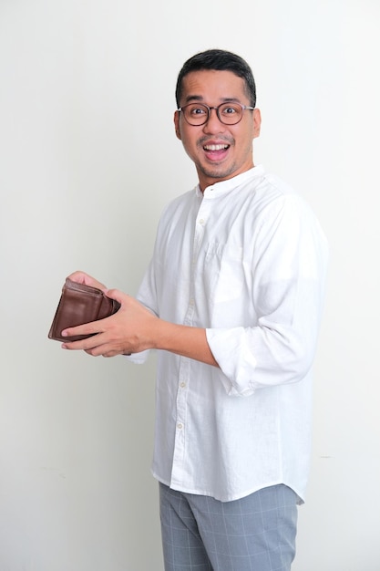 Adult Asian man looking camera while open his wallet showing happy expression