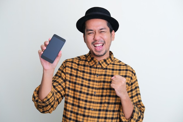 Adult Asian man showing blank mobile phone screen with happy expression