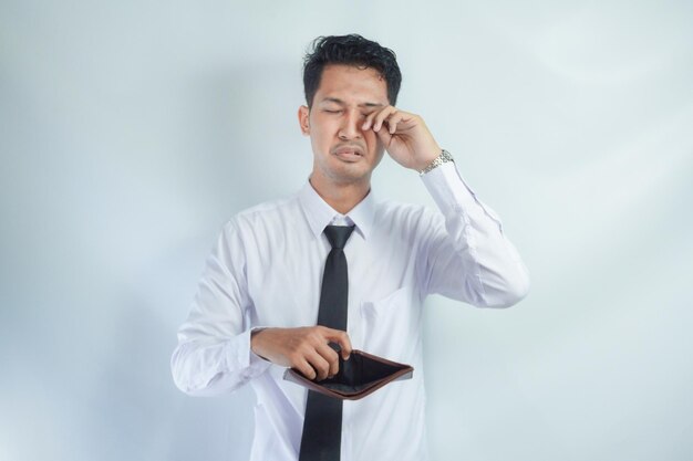 Photo adult asian man showing his empty wallet with worried expression