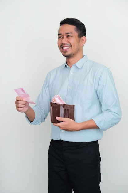 Adult Asian man smiling while giving money to someone