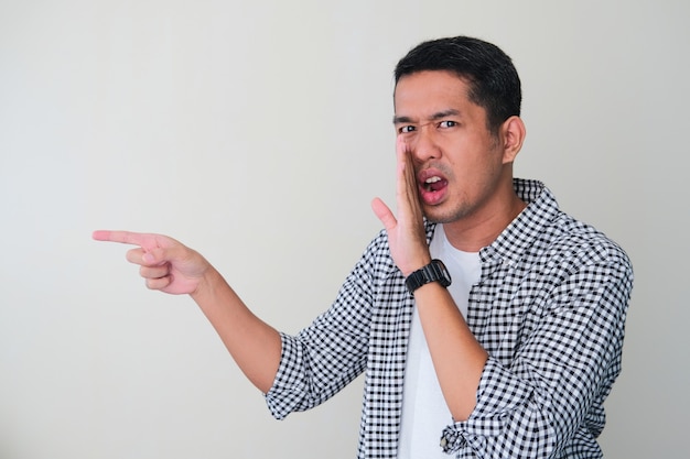 Photo adult asian man whispering gossip and pointing finger to someone