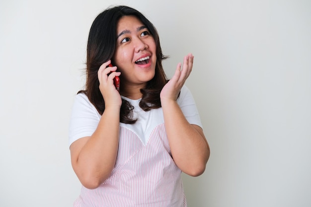 Взрослая азиатская женщина показывает счастливое выражение при разговоре с кем-то по телефону