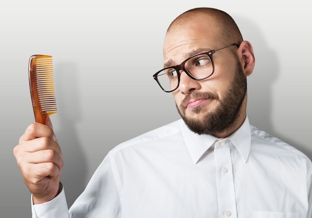 Adult bald  man hand holding comb