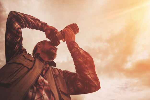 写真 空の背景にカメラを持つ大人のひげを生やした男性