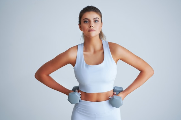 Adult beautiful woman working out over light background