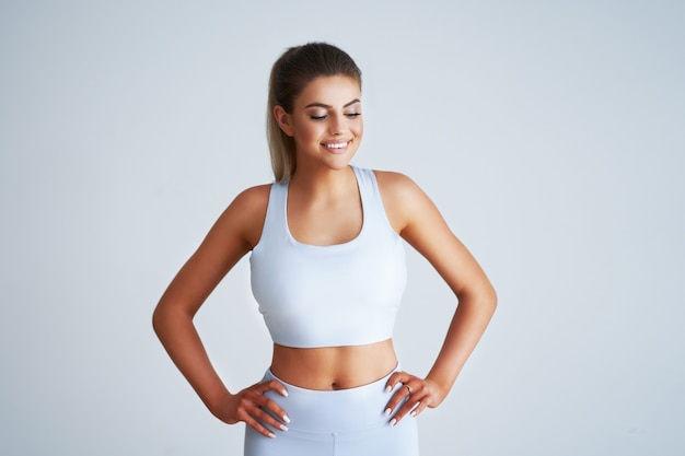 Adult beautiful woman working out over light background