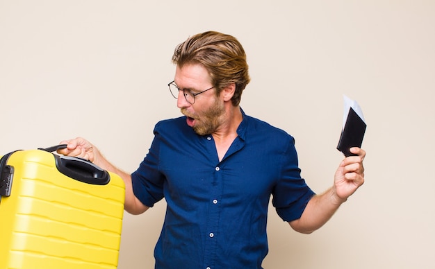 Uomo biondo adulto con un caso. concetto di viaggio.