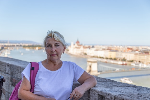 Adult blonde woman tourist in a bridge