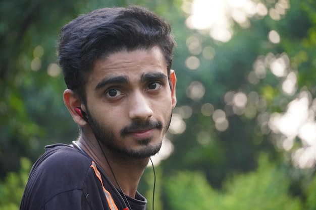 Adult boy in park watching in camera