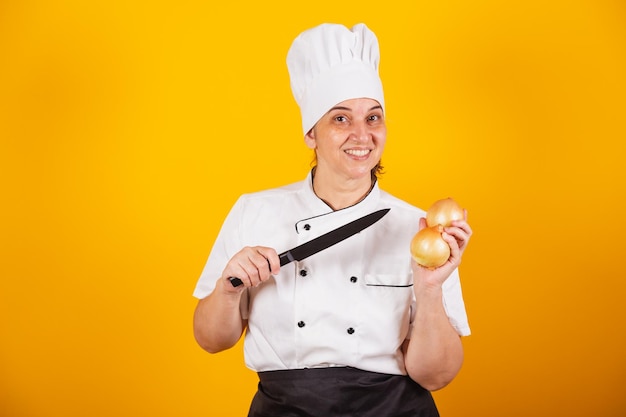 Adult Brazilian woman chef master in gastronomy holding onion and knife