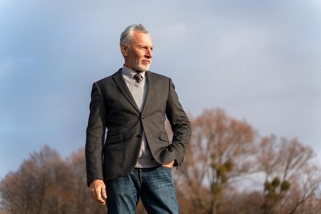 Adult business man in jacket looking away in the park