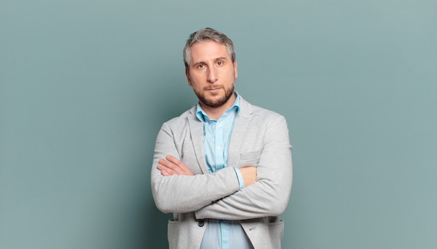 Adult businessman feeling displeased and disappointed, looking serious, annoyed and angry with crossed arms